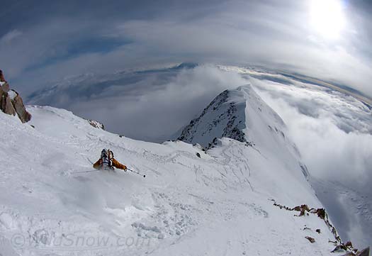 6-14-P6113748-ski-on-ridge-frida One of the WildSnow boys throws some snow around on Denali West Buttress. About 2/3 of of ridge from 16,200 to 17,200 is skiable given soft snow conditions, but it frequently ices up and is not safe to ski. Most of the ridge drops off to an abyss on either side. Spectacular to gliss but a bit unnerving.