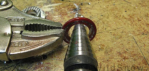 Drill out red washer with step bit so it fits the external portion of the screw rivet. Drill out red washer with step bit so it fits the external portion of the screw rivet.