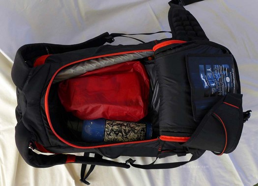 Lightweight items—-shell and warm mitts-—towards the outside, heavier thermos/water bottle and food bag next, insulated and nestled in a puffy outer layer. Shovel blade fits on top. Lightweight items—-shell and warm mitts—-towards the outside, heavier thermos/water bottle and food bag next, insulated and nestled in a puffy outer layer. Shovel blade fits on top.