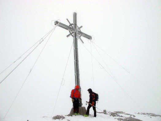 Franz bergheils each skier at the ice encrusted summit cross. Cold and windy, but always nice to reach a new summit. Franz bergheils each skier at the ice encrusted summit cross.