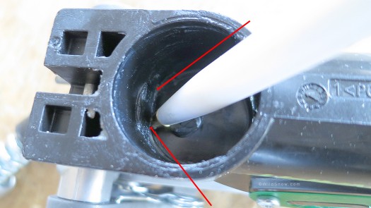 View inside Beast 16 rear unit, socket where heel post-spindle inserts. Slot or ledge that aluminum flange locks behind is easily visible at tip of pen, indicated by red arrows.