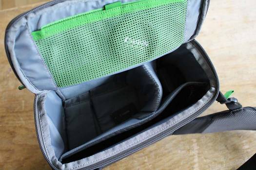 Spacious belt pack with velcro dividers for customizable compartments. Top green mesh pocket for lens filters.