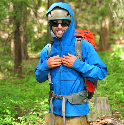 OR Axiom features a hood big enough to fit over a helmet, and pockets that remain accessible with a pack or harness on. OR Axiom features a hood big enough to fit over a helmet, and pockets that remain accessible with a pack or harness on.