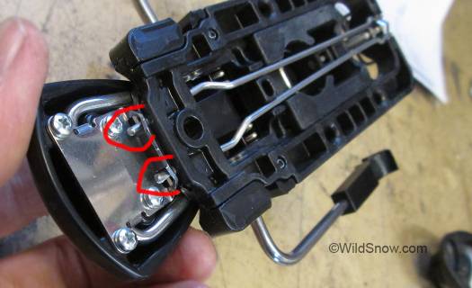 Underside of heel unit viewed from front showing how the rods of the brake lock hold the retractor plate until pulled rearward. Underside of heel unit viewed from front showing how the rods of the brake lock hold the retractor plate until pulled rearward.
