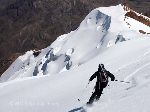 Mike Marolt skiing Illimani with views of the valley and the start way below.