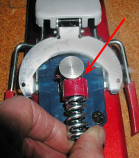 Dynafit heel with housing removed, spring and thimble bushing held in operative position. Arrow indicates where edge of aluminum post wears into bushing. Dynafit heel with housing removed, spring and thimble bushing held in operative position. Arrow indicates where edge of aluminum post wears into bushing.