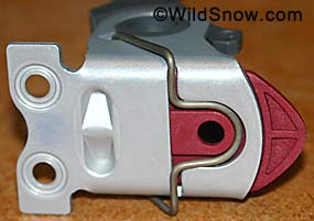 This shows correct assembly of heel unit before screwing down on ski. When unit is attached, spring should compress into slot. Check as you screw it down.