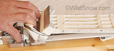 Changing from downhill to touring modes is done by pulling the toe of the binding plate up, which releases the white plastic touring plate from a catch. Reverse procedure changes back to downhill. Both require exiting the binding.