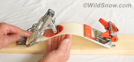 Heel latchdown is done by bending the plastic plate up in the middle, thus allowing a tab on the rear of the binding to slip under a catch. Heel latchdown is done by bending the plastic plate up in the middle, thus allowing a tab on the rear of the binding to slip under a catch.
