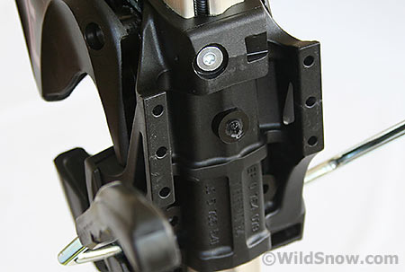 Bottom of heel unit showing legs (with holes) that rest on ski. These are farther apart and longer than those of previous models, and are said to make the binding more stable. Bottom of heel unit showing legs (with holes) that rest on ski. These are farther apart and longer than those of previous models, and are said to make the binding more stable.