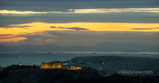 The Parthenon lit up at night and the Aegean Sea. 