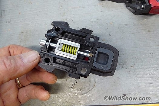 Underside of heel unit, ski flex compensation spring. The binding is set for boot length with a 'kiss' gap between boot heel and binding. Underside of heel unit, ski flex compensation spring. The binding is set for boot length with a 'kiss' gap between boot heel and binding.