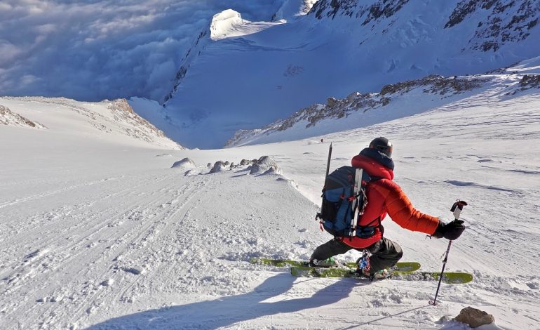 Drew watches Cal (far away center) ski the Messner Couloir in tricky conditions. His skis were some of the larger you would find on Denali and it paid off here. Photo @g.allen.smith