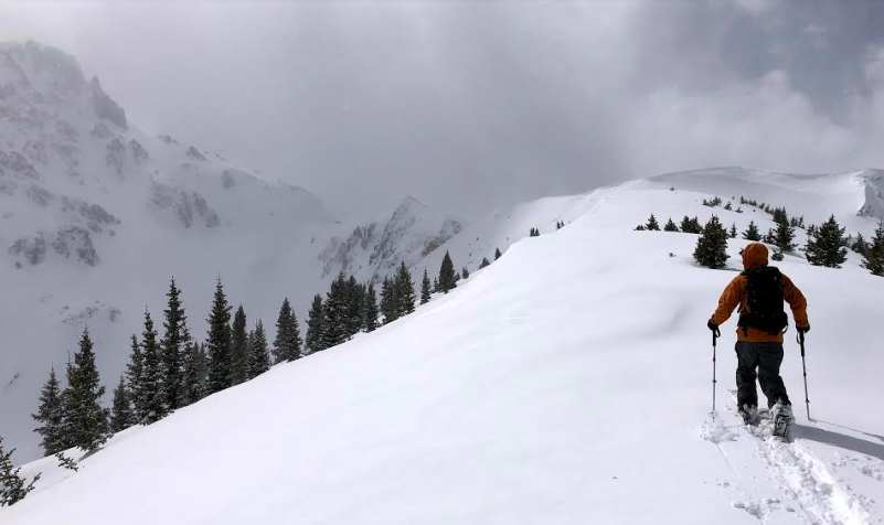 Skinning out on a snowy ridge with a transition looming. This is a good example of pausing before breaking out of the treeline to add layers, etc.