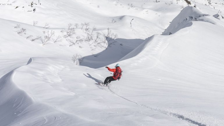 Lay'n back and slashing on a slushy day, Putting the poles on the pack opens the soul to all of the freedom the terrain offers. Hakuba Backcountry, Japan. Photo: Rolland Miller