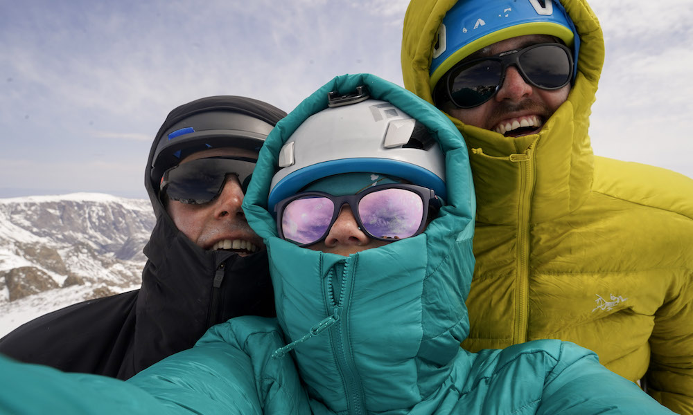All smiles atop our first summit of the trip. It was cold and gusting, but the grey overcast was clearing. It kept us hopeful that the next few days would produce clearer, warmer weather. (Photo: @morgankelsey)