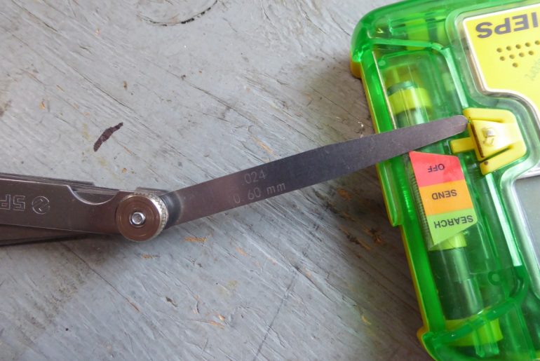 The lock tab protrudes about 0.6 millimetres, determined using my feeler gauges.