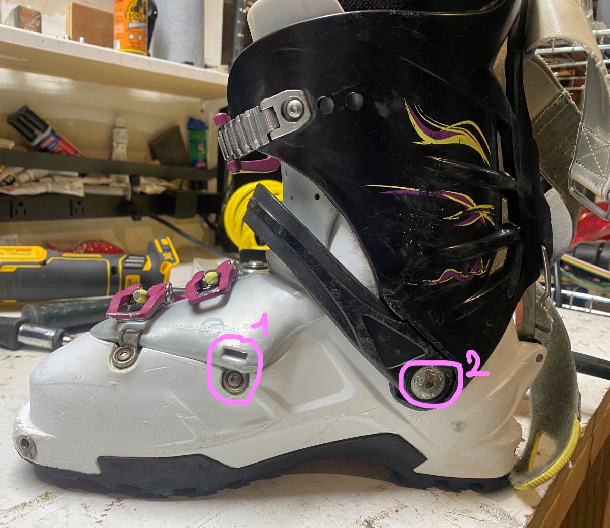 Circle #1 shows a missing hinge, which in the case of this particular boot doesn't impact its functionality and is also easily replaceable. Circle #2 shows a common part to go missing, make sure to check that it is in its place. These pivots can wear out and develop play which is nearly impossible to fix and will affect ski performance. One way to check for this is by wiggling the cuff of the boot in ski mode, checking for play.