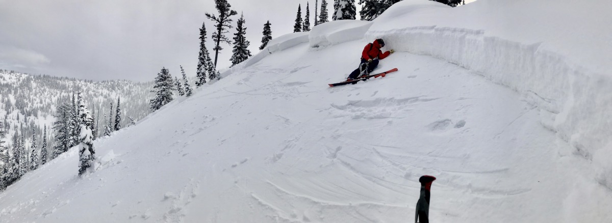 Flathead Avalanche Center forecaster Cam Johnson examining the crown of a nasty April Fool's joke. The slide was remotely triggered from the ridge above and ran on a thin layer of recently-buried facets. Flathead Range, MT, April 1, 2020.