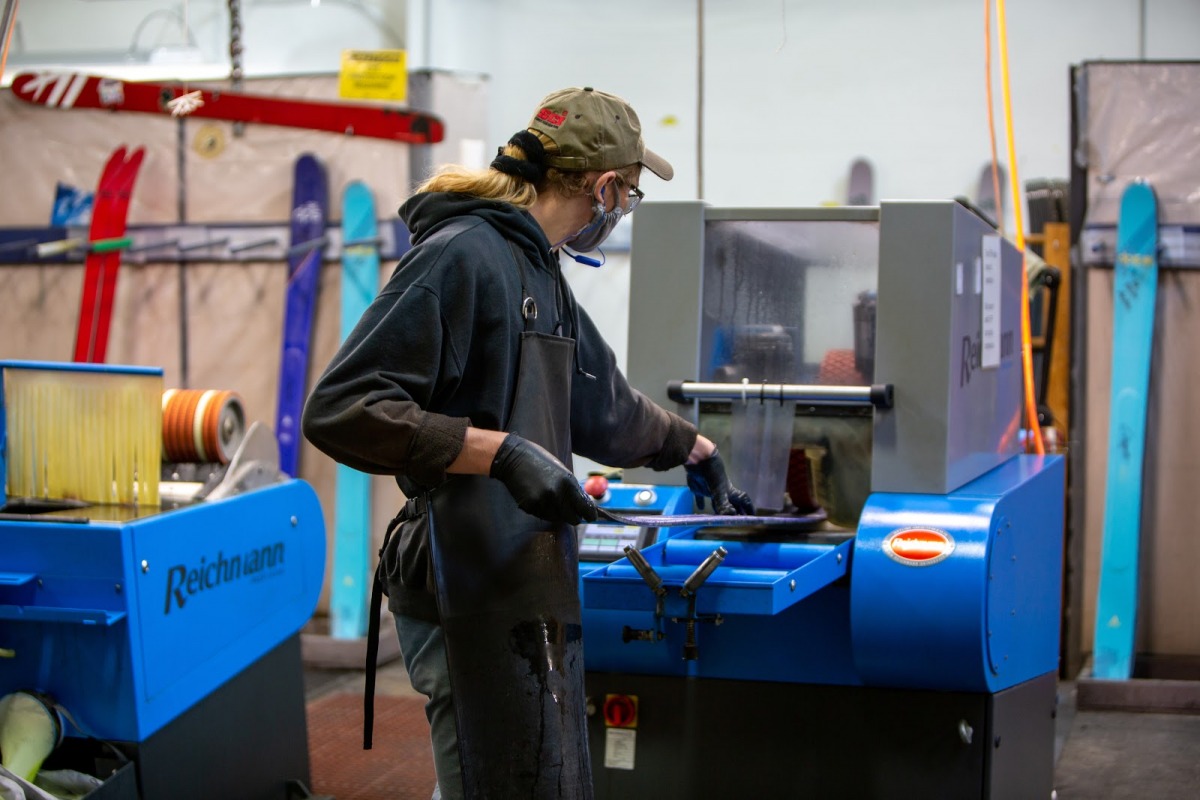 The finishing room is where the 'twins are split' and refined to a skiable condition. After that edges are sharpened and bases are structured before getting sent for inspection. Here a base structure is being put into a freshly split twin.