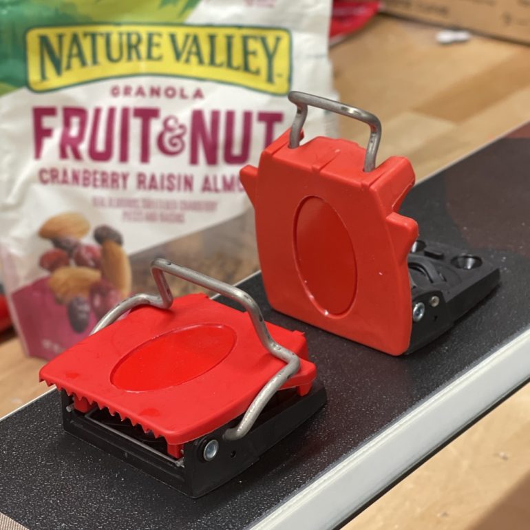 The standard heel piece on the right, the new one on the left. The new design for the metal second heel is far more stable, but is lower than the red, whereas the original metal heel is higher than the red, but unstable.