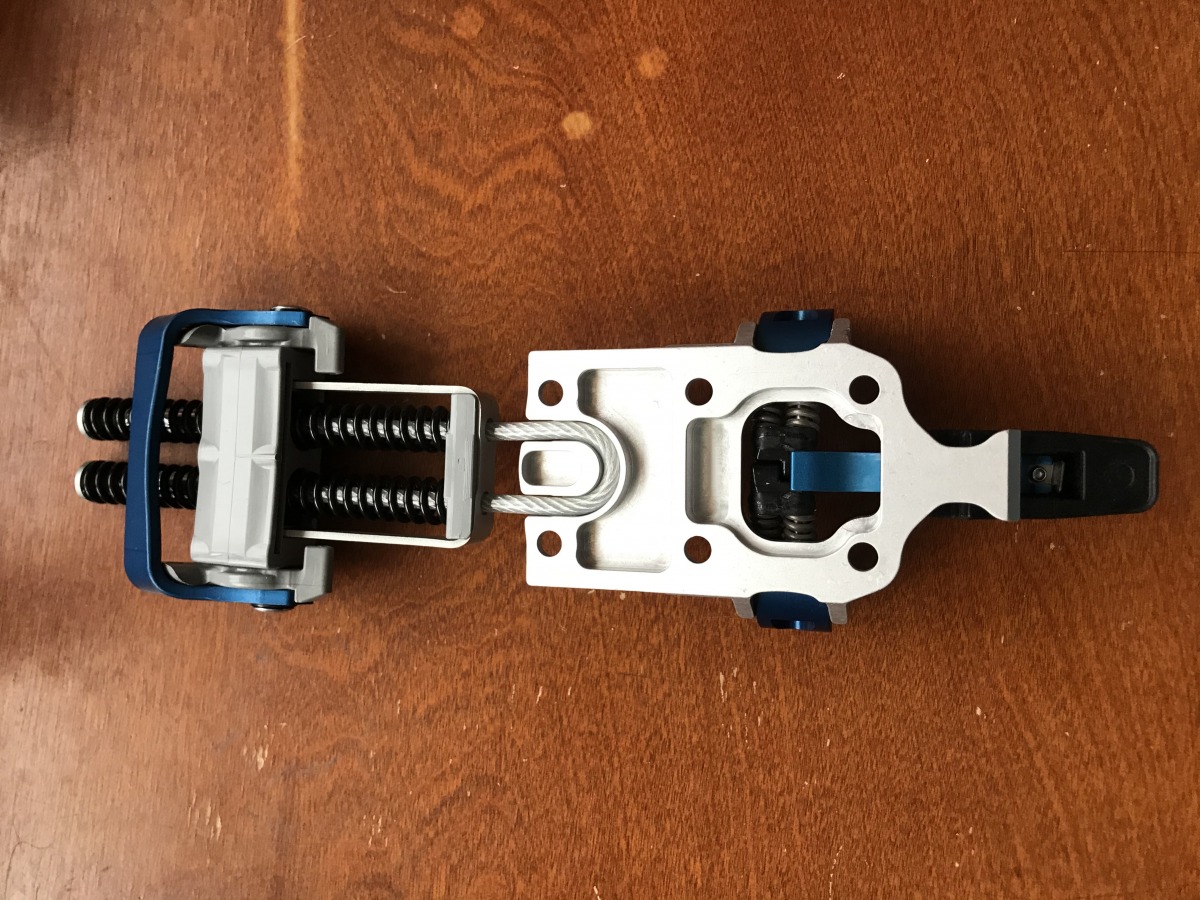 A U-shaped groove in the bottom of the toe piece holds the cable & coil spring arrangement of the claw captive once mounted to the ski.